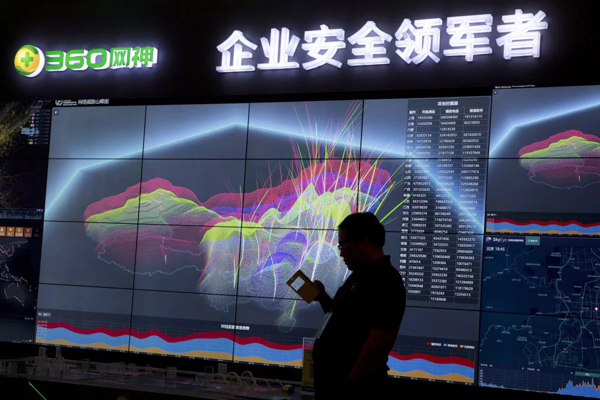 A worker is silhouetted against a computer display showing a live visualization of the online phishing and fraudulent phone calls across China in this file photo. China Telecom was caught employing a different method of cyber spying, namely diverting internet traffic. (AP Photo/Ng Han Guan, File)