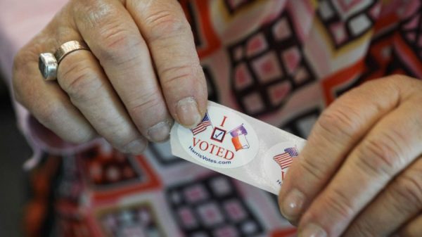 A voter in Texas hands out "I voted" stickers