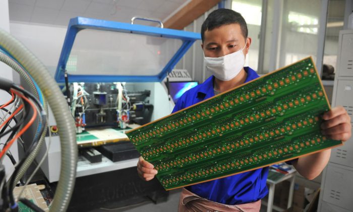A worker checks a circuit board at a factory in Hangzhou in eastern China's Zhejiang Province, on May 22, 2018. (AFP/Getty Images)