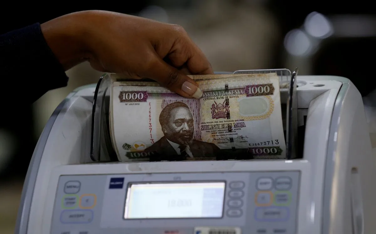 A Kenya Commercial Bank (KCB) worker counts Kenya shilling notes on a money counting machine as she serves a client inside in the banking hall at the Kencom branch in Nairobi on July 10, 2018. (Thomas Mukoya/Reuters)