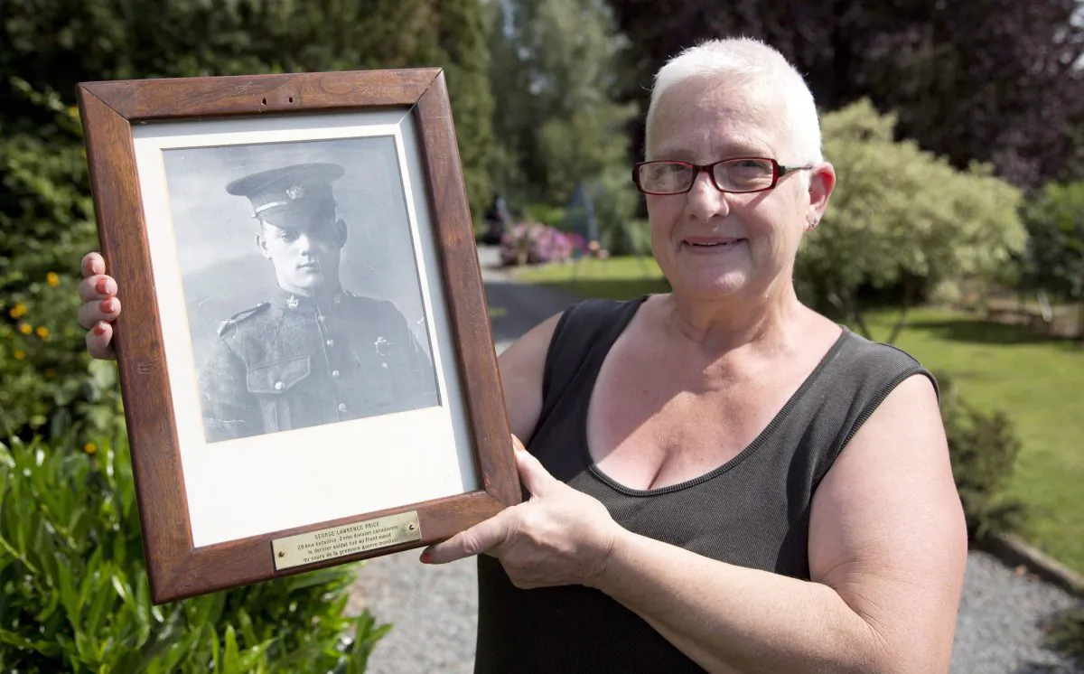 Marilyn Lahaeu with photo of World War I soldier Pvt. George Lawrence Price near her home in Ville-sur-Haine, Belgium on Sunday, Aug. 3, 2014. (Virginia Mayo/The Canadian Press/AP)