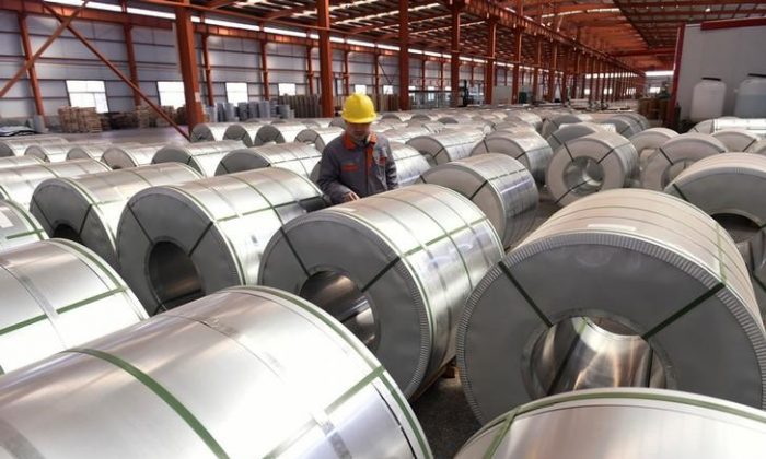 A worker checks aluminum rolls at a warehouse inside an industrial park in Binzhou, Shandong Province, China, on April 7, 2018. (China Daily via Reuters)
