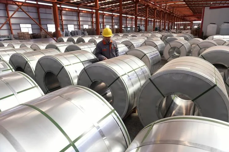A worker checks aluminum rolls at a warehouse inside an industrial park in Binzhou, Shandong Province, China on April 7, 2018. (China Daily via Reuters)