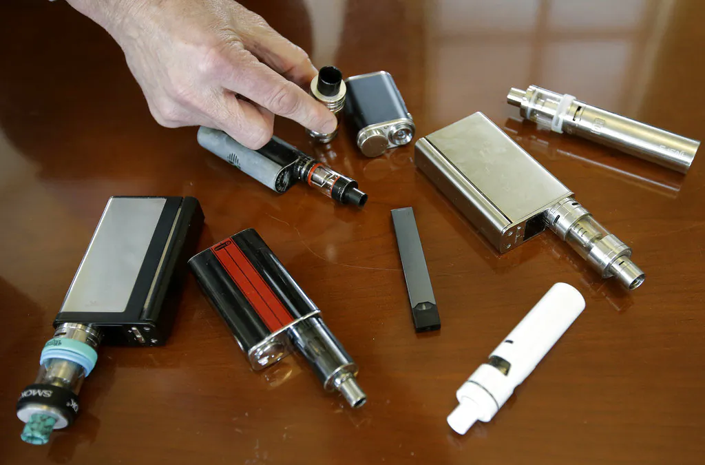 A high school principal displays vaping devices that were confiscated from students in such places as restrooms or hallways at the school in Massachusetts on Apr. 10, 2018. (AP/Steven Senne)