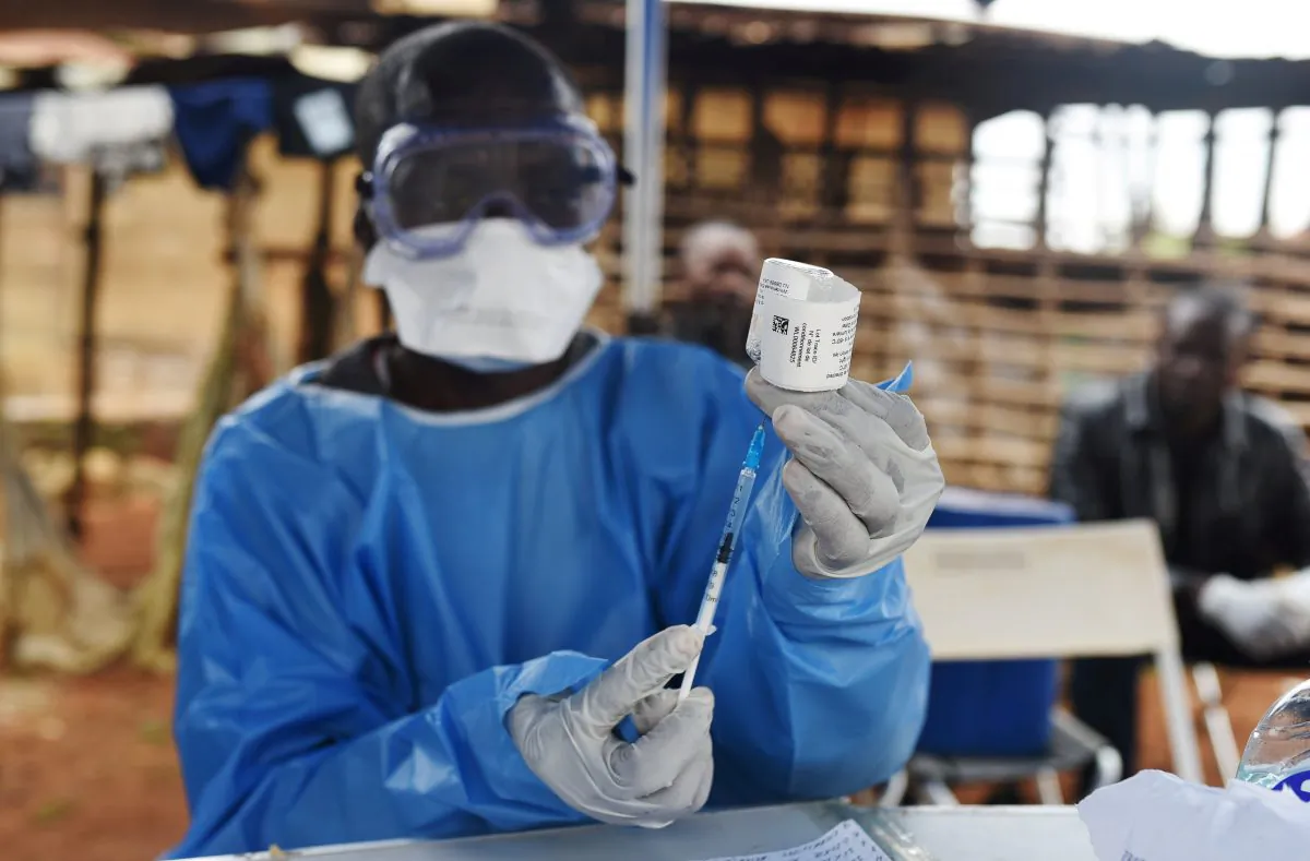 A Congolese health worker prepares to administer an Ebola vaccine, outside the house of a victim who died from Ebola in the village of Mangina in North Kivu Province of the Democratic Republic of Congo, on Aug. 18, 2018. (Olivia Acland/Reuters)