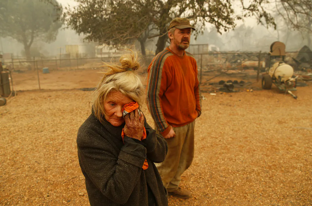 Cathy Fallon wipes her face beside her son Gabriel Fallon as she stands near the charred remains of her home Friday, Nov. 9, 2018, in Paradise, Calif. "I'll be darned if I'm gonna let those horses burn in the fire" said Fallon, who stayed on her property to protect her 14 horses, "It has to be true love." All of the horses survived. (John Locher/AP Photo)