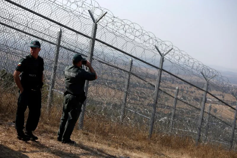 Bulgarian border policemen stand near the barbed wire fence constructed on the Bulgarian-Turkish border, near Lesovo, Bulgaria, on Sept. 14, 2016. (Stoyan Nenov/Reuters)