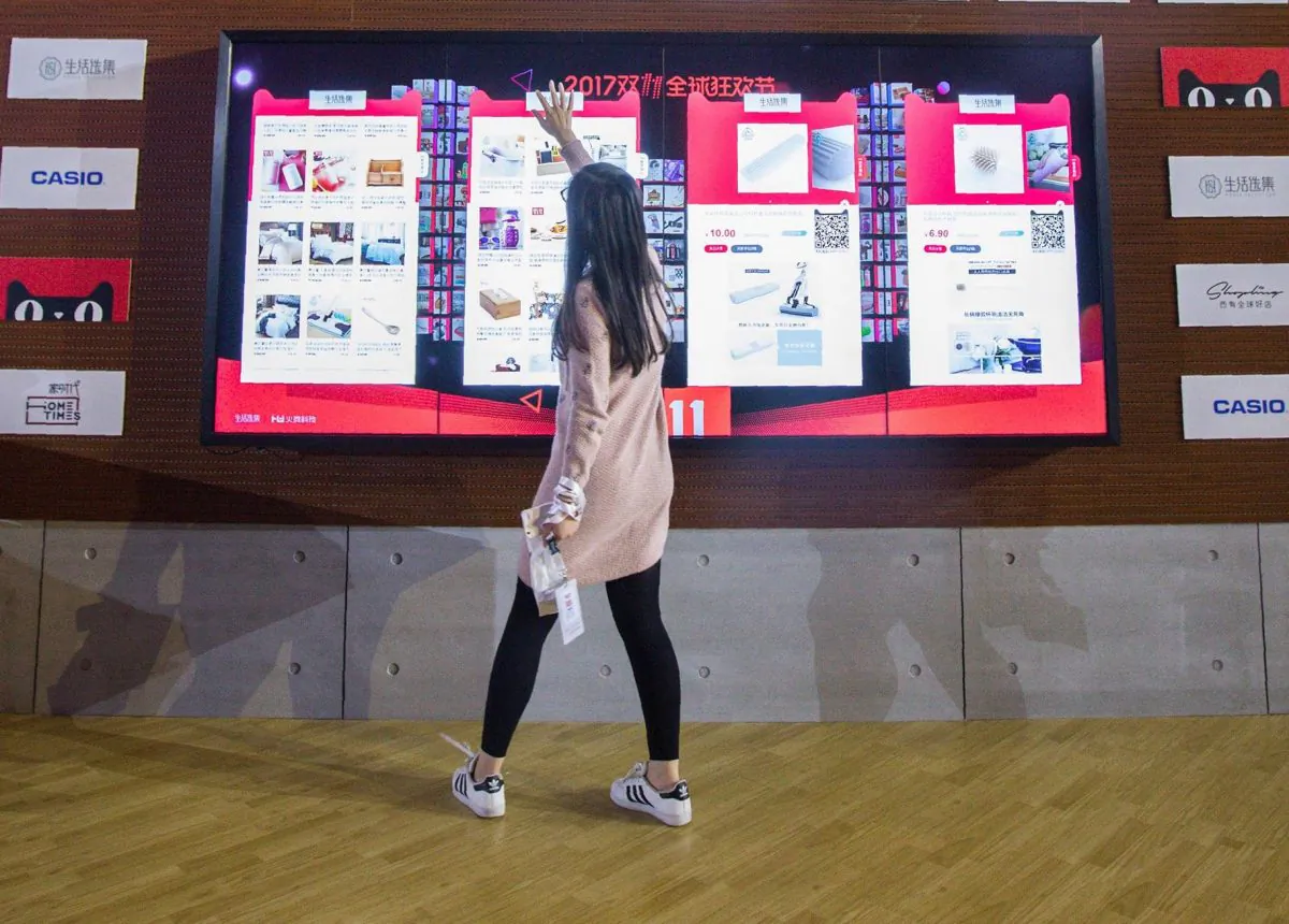 A woman looks at goods on an electronic screen at a T-Mall exhibition during the Singles Day shopping festival in Shanghai on November 11, 2017. (STR/AFP/Getty Images)