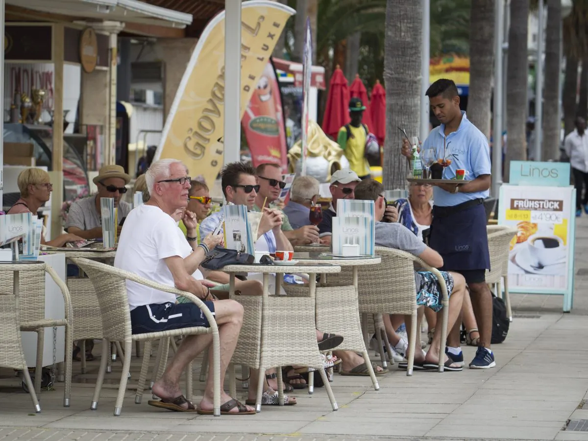 A waiter serves tourists sitting at a restaurant along Palma's Beach on Palma de Mallorca, Spain, in this file photo. (Jaime Reina/AFP/Getty Images)