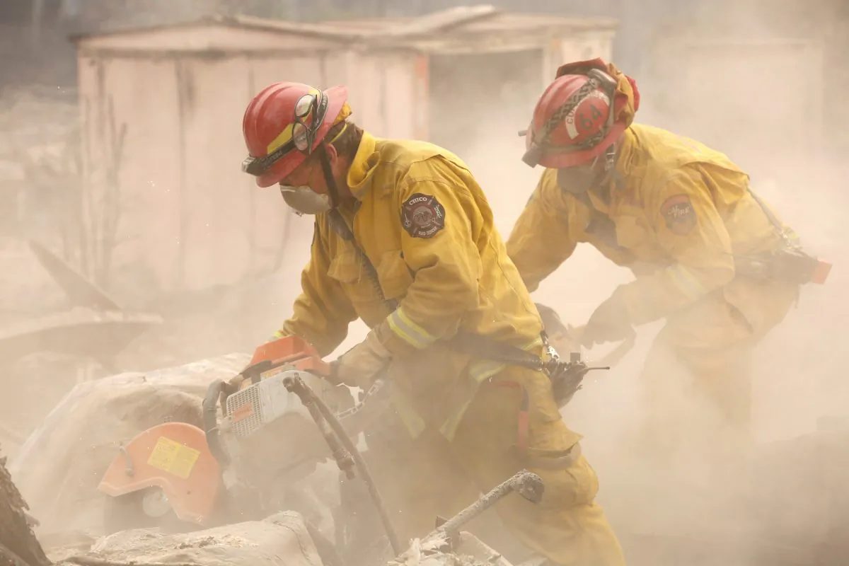 Cal Fire firefighters comb through a house destroyed by the Camp Fire in Paradise, California, November 13, 2018. (Terray Sylvester/Reuters)