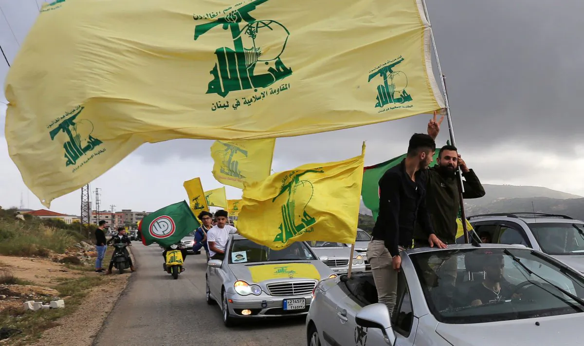 A supporter of Lebanon's Hezbollah gestures as he holds a Hezbollah flag in Marjayoun, Lebanon May 7, 2018. (Reuters/Aziz Taher)