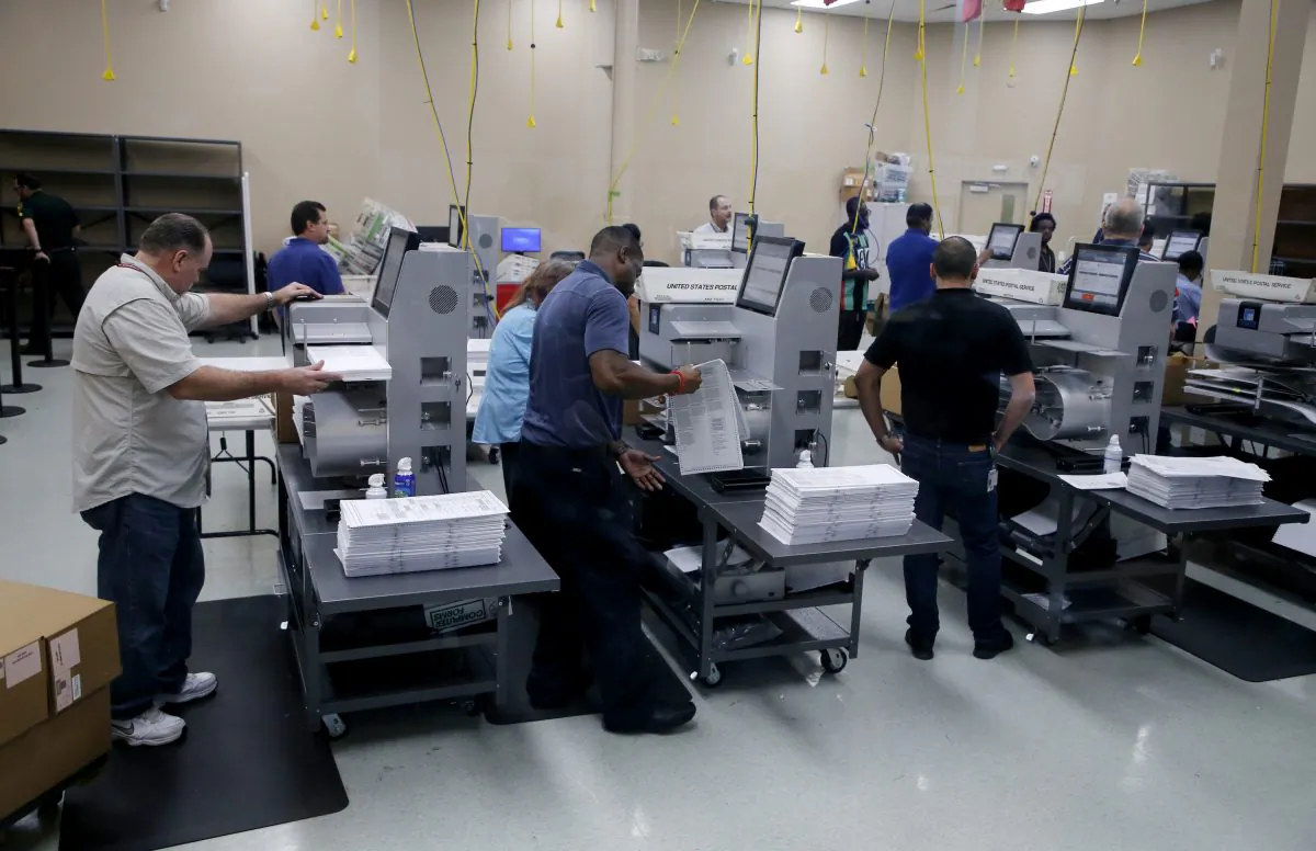 Elections staff load ballots into machines as recounting begins at the Broward County Supervisor of Elections Office on November 11, 2018 in Lauderhill, Florida. (Joe Skipper/Getty Images)