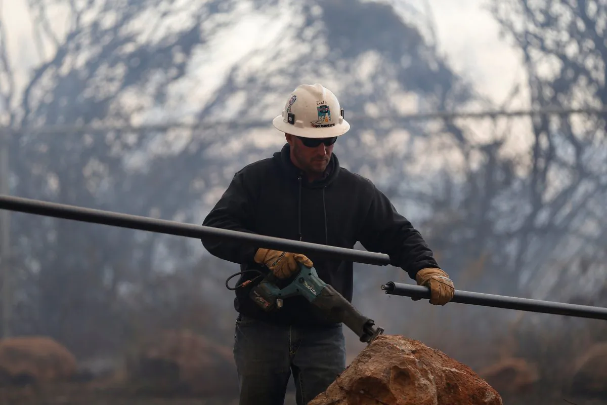 A Pacific Gas & Electric lineman cuts a downed power line during the Camp Fire in Paradise, California, U.S. November 8, 2018. (Stephen Lam/Reuters)