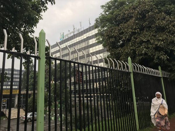 woman walks past Telecom Addis