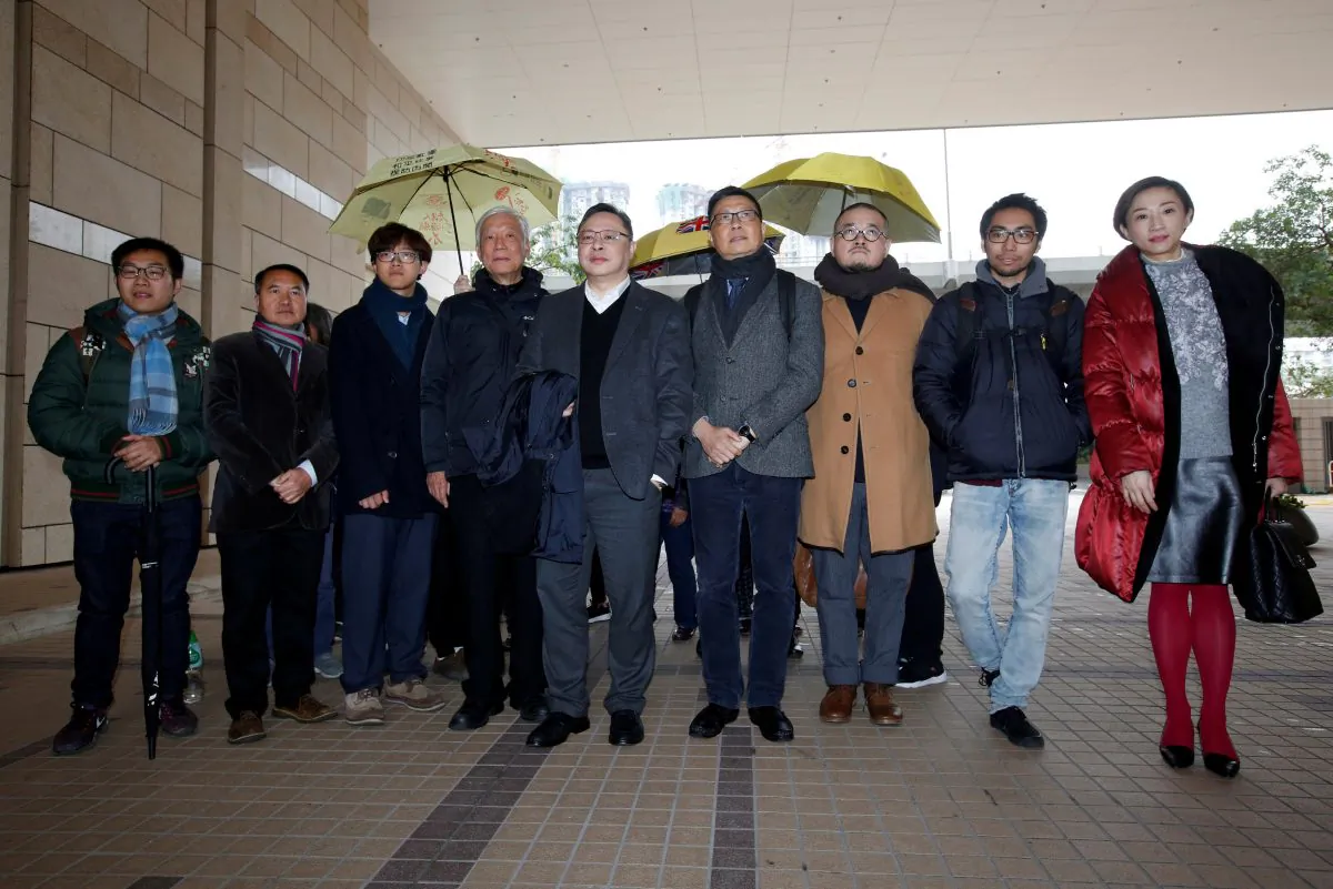 (L-R) Pro-democracy activists Raphael Wong, Lee Wing-tat, Cheung Sau-yin, Chu Yiu-ming, Benny Tai, Chan Kin-man, Shiu Ka-chun, Chung Yiu-wa and Tanya Chan pose outside a court after a pre-trial hearing in Hong Kong, China on Jan. 9, 2018. (Bobby Yip/Reuters)