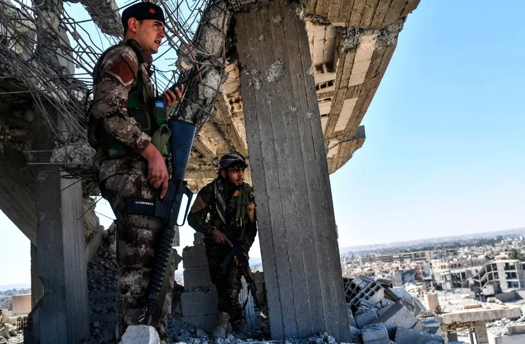 Members of the Syrian Democratic Forces, backed by U.S. special forces, walk on a building near Raqa's central hospital as they clear the last positions on the frontline on Oct. 16, 2017, in the ISIS group jihadists' crumbling stronghold. US-backed fighters have battled hundreds of ISIS jihadists holed up in the last pockets of Syria's Raqa, as the former extremist stronghold stood on the verge of capture. (Bulent Kilic/AFP/Getty Images)US-backed fighters battled hundreds of ISIS jihadists holed up in the last pockets of Syria's Raqa, as the former extremist stronghold stood on the verge of capture. (BULENT KILIC/AFP/Getty Images)