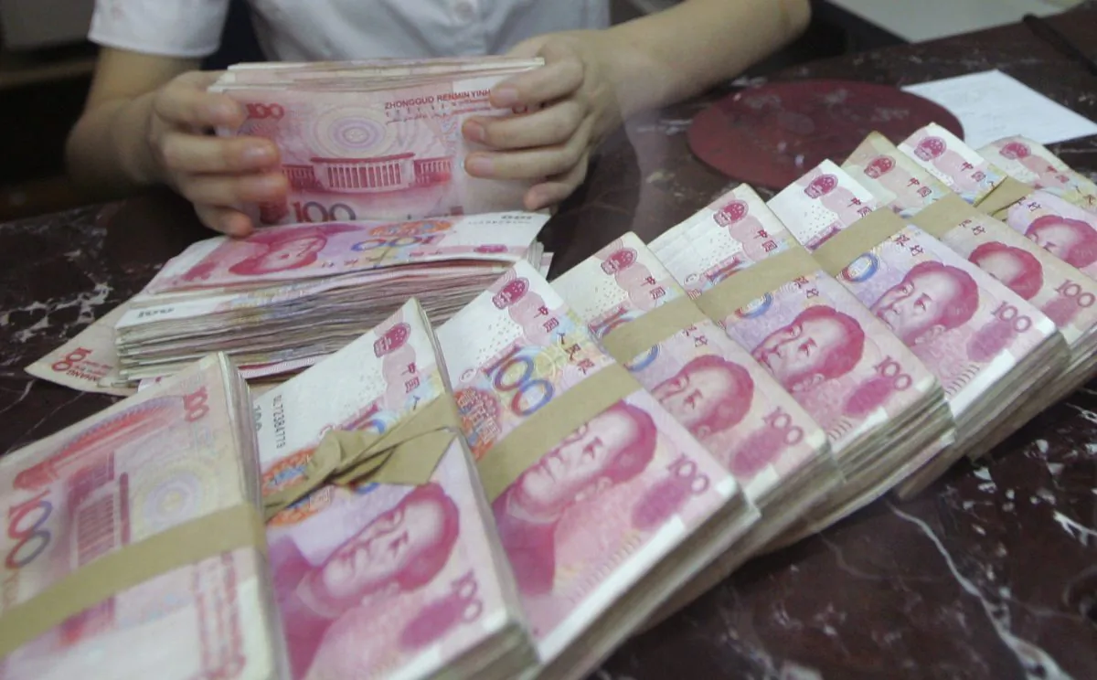 An employee counts Chinese 100 yuan banknotes at a branch of Bank of Communications in Shenyang, Liaoning Province, China on July 6, 2012. (Reuters)