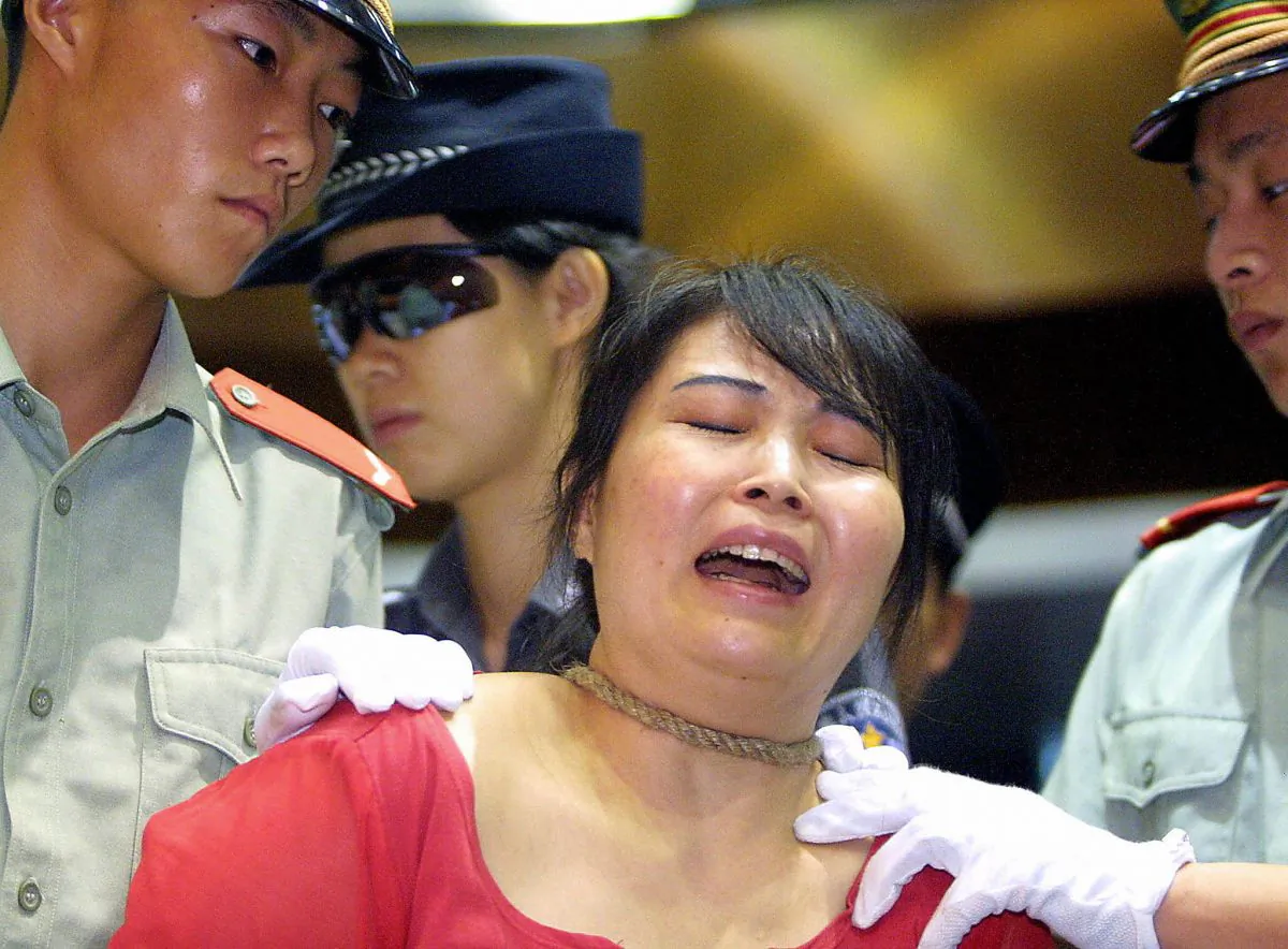 Convicted drug pedlar Wang Xiongyin breaks down as she Is sentenced to death for selling 200 grams of heroin for 27,000 yuan back in 1999, in Guangzhou, 26 June 2003, as China marks the International Anti-Drugs Day. (STR/AFP/Getty Images)