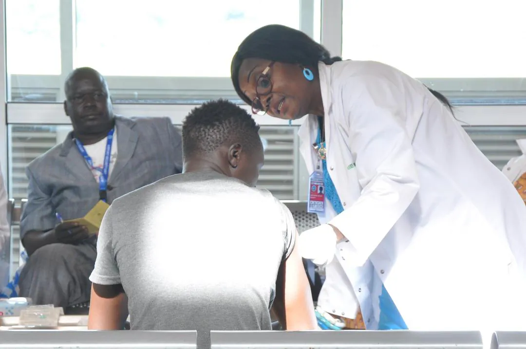 A medical officer offers consultation to a returnee from Niger upon arrival at the Yaounde Nsimalen International Airport in Cameroon on May 9, 2018. (IOM/Serena Pescatore)