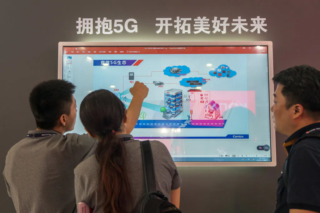 People watch a screen showing information on 5G technology during the Mobile World Conference in Shanghai on June 27, 2018. (-/AFP/Getty Images)