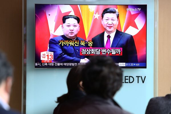 South Koreans watch a television broadcast reporting the North Korean leader Kim Jong-un met with Chinese leader Xi Jinping.