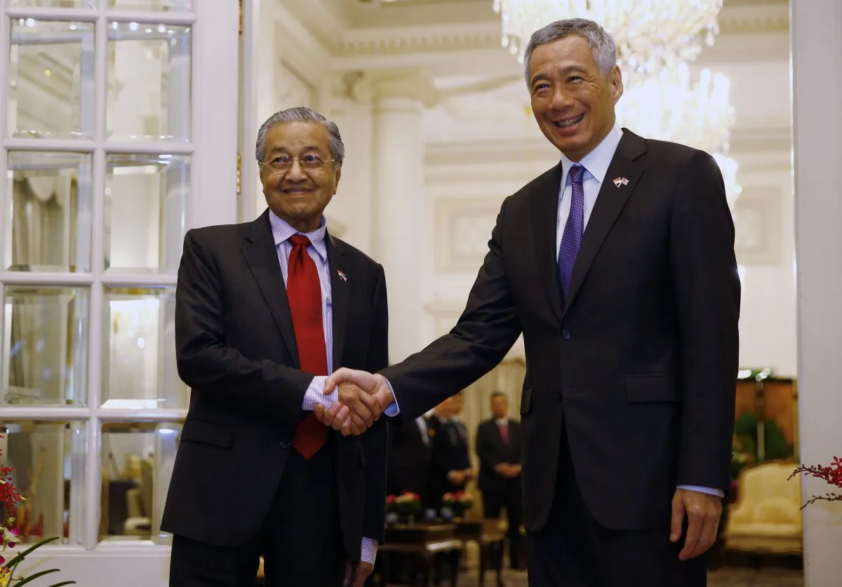 Malaysia's Prime Minister Mahathir Mohamad (R) shakes hands with Singaporean counterpart Lee Hsien Loong during a meeting at the Presidential Palace on the sidelines of the 33rd Association of Southeast Asian Nations (ASEAN) summit in Singapore on Nov. 12, 2018. (FELINE LIM/AFP/Getty Images)