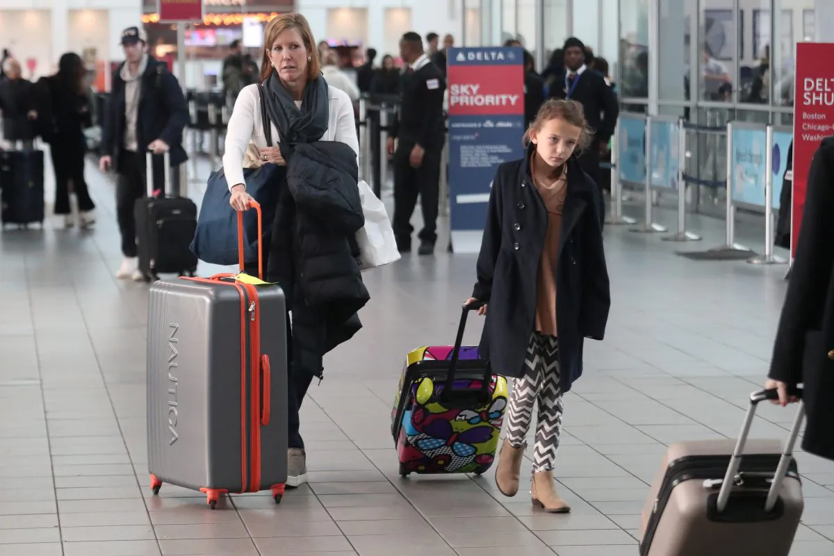 People carry their luggage in the Delta air terminal at LaGuardia Airport in New York on Nov. 20, 2018. (REUTERS/Shannon Stapleton)