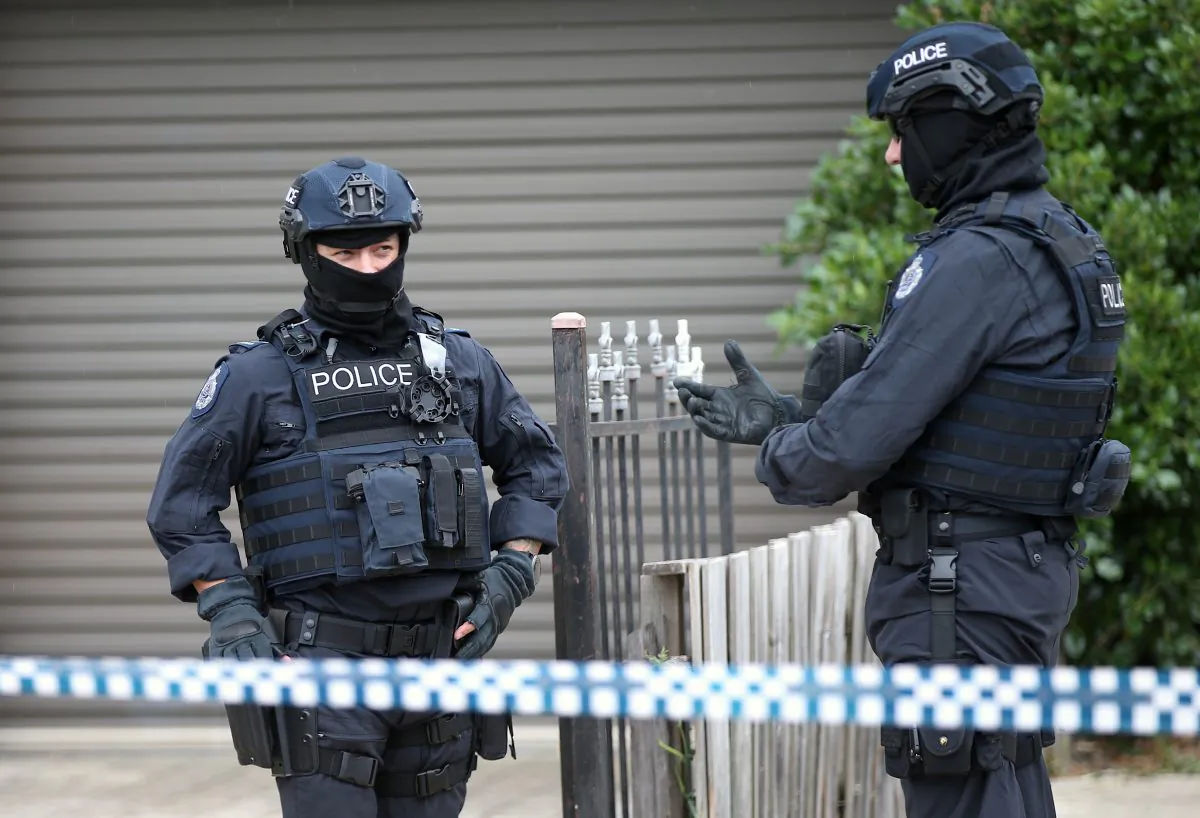 Police officers that form part of the Australian Joint Counter Terrorism Team stand outside a home they raided as part of an operation in which they arrested three men who were allegedly preparing to attack the public in Melbourne, Australia, on Nov. 20, 2018.  (AAP/David Crosling/via Reuters)