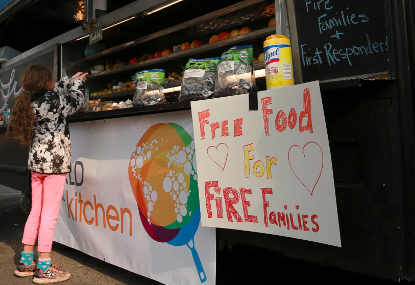 Miruia Eubanks, 9, grabs some free food from a food truck in Chico, California, U.S. November 20, 2018.  (Elijah Nouvelage/Reuters)