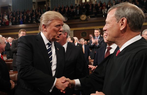 President Donald Trump (L) shakes hands with Chief Justice John Roberts (R) in the House chamber of the U.S. Capitol