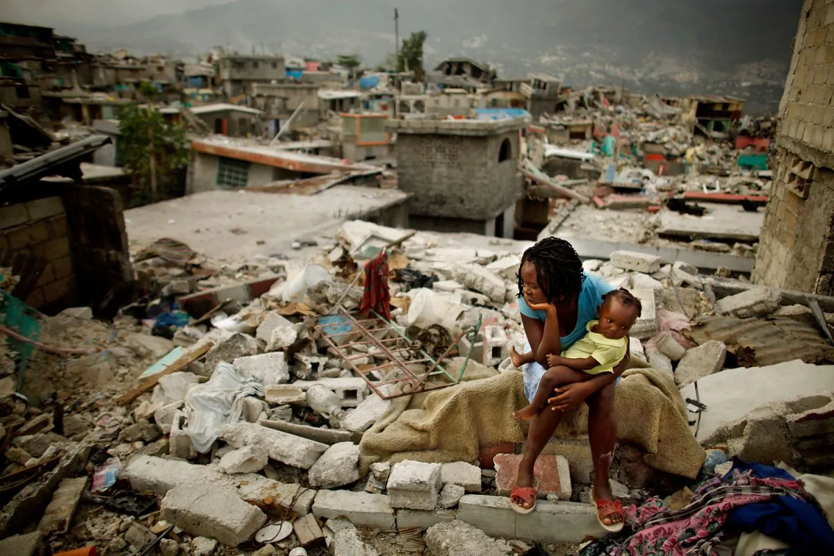 Sherider Anilus, 28, and her daughter, 9-month-old Monica, sit on the spot where her home collapsed during 2010's 7.0 earthquake in Port-au-Prince, Haiti. (Chip Somodevilla/Getty Images)