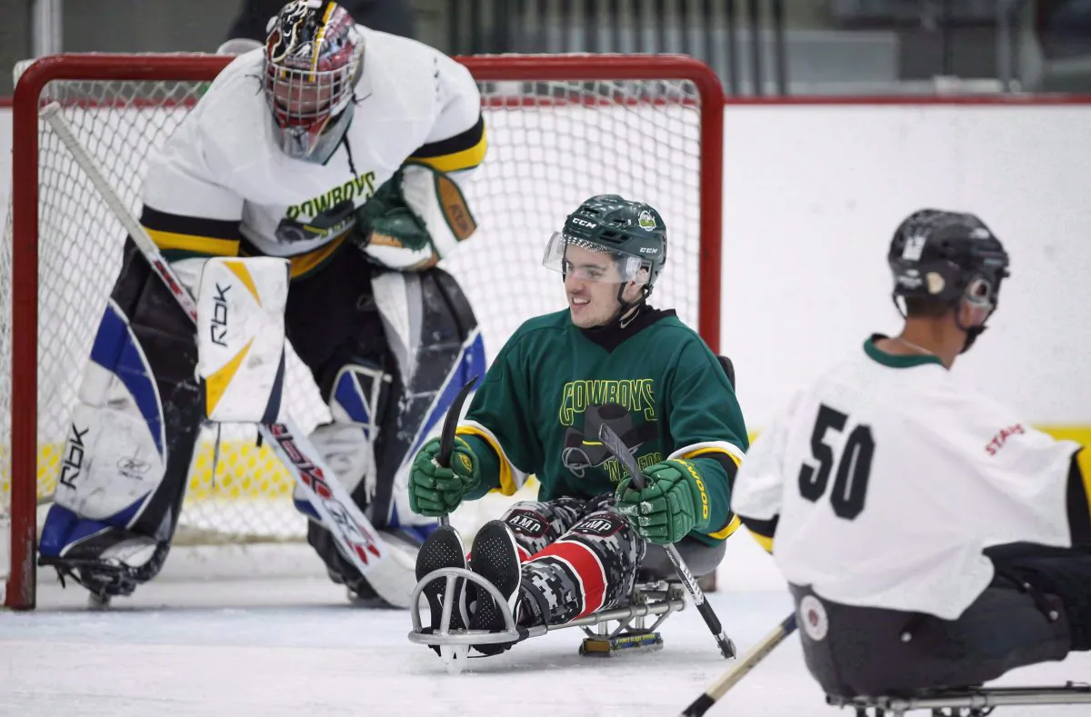 Humboldt Broncos bus crash survivor Ryan Straschnitzki (2-L) plays in a fundraising sledge hockey game in Calgary, Alta.,on Sept. 15, 2018. (The Canadian Press/Jeff McIntosh)