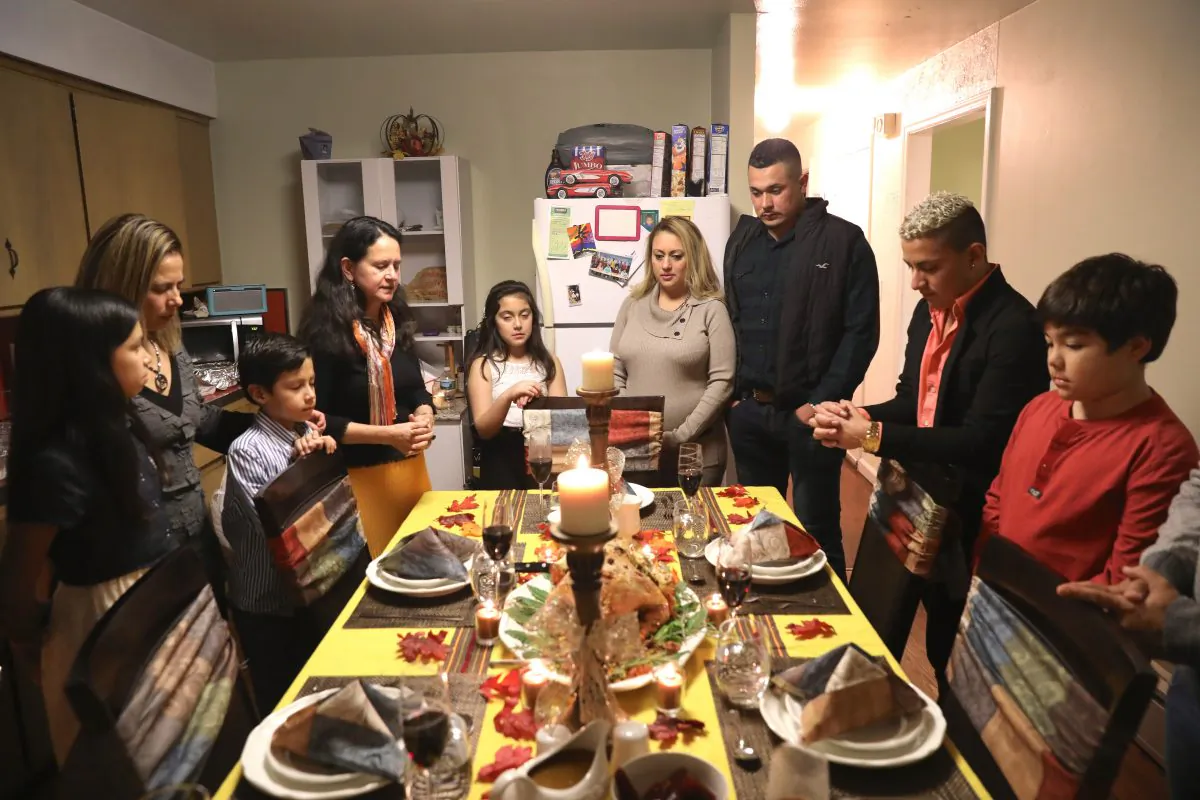 Friends and families pray before Thanksgiving dinner in Stamford, Conn., on Nov. 24, 2016. (John Moore/Getty Images)