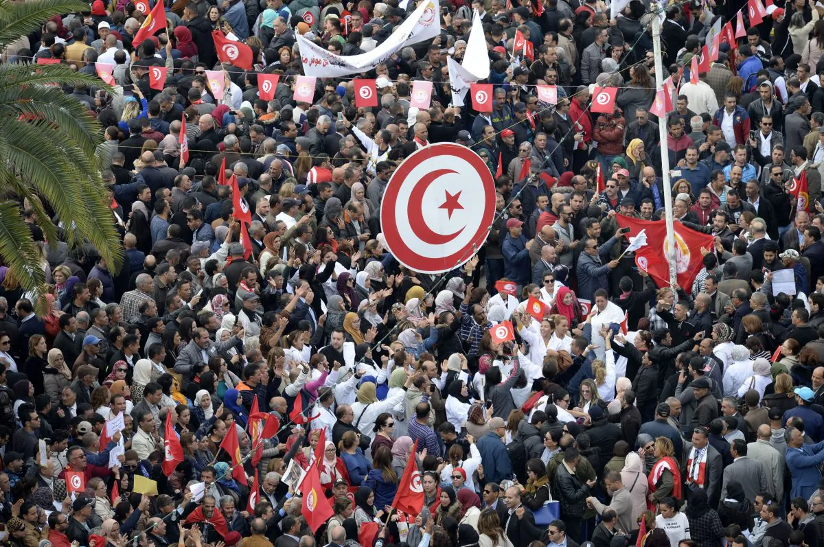 Tunisian protesters wave national flags and chant slogans during a civil servants general strike after the failure of negotiations with the government on salary increases in the capital Tunis on Nov. 22, 2018. FETHI BELAID/AFP/Getty Images)