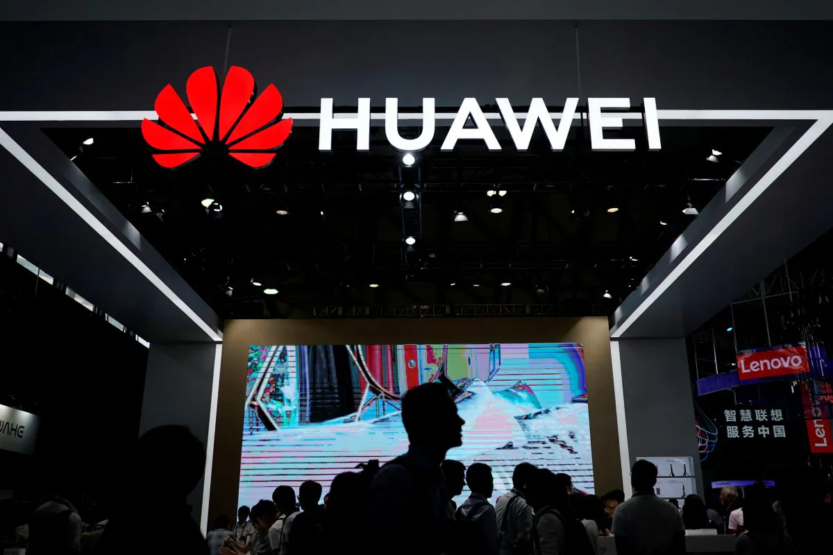People walk past a sign board of Huawei at CES (Consumer Electronics Show) Asia 2018 in Shanghai, China on June 14, 2018. (Aly Song/Reuters)