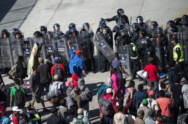Central American migrants are blocked by Mexican police forces as they reach the El Chaparral border crossing, in Tijuana, Baja California State, Mexico