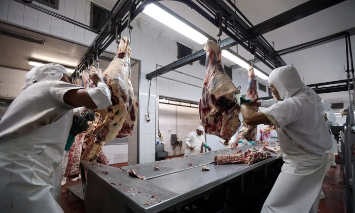 Workers handle beef carcasses at the Ecocarne Meat Plant slaughterhouse in San Fernando, Argentina, on June 26, 2017. (Marcos Brindicci/Reuters)