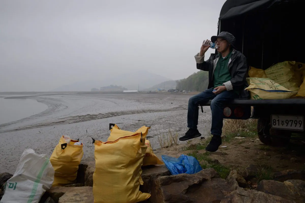 A North Korean defector activist sits with bags of bottles containing rice, money, and USB sticks, on Ganghwa island, west of Seoul, on May 1, 2018. North Korean defectors send the supplies floating towards their homeland. (Ed Jones/AFP/Getty Images)