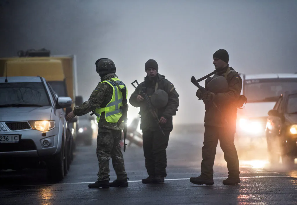 Ukrainian national guard soldiers and a police officer stop a car to check documents at the checkpoint near the city of Mariupol, south coast of Azov sea, eastern Ukraine, on Nov. 27, 2018. (Evgeniy Maloletka/AP Photo)
