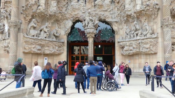 Tourists take photos by the Basilica of the Sagrada Familia in Barcelona.