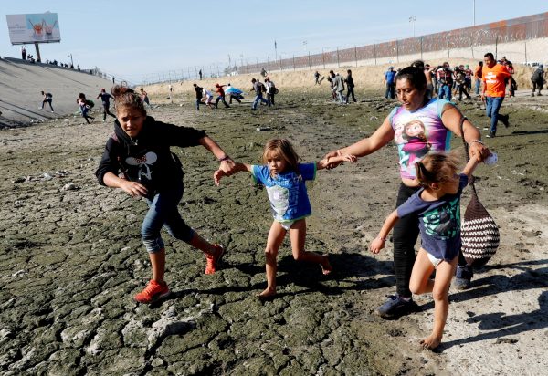 a woman and her young children at the border between US and Mexico