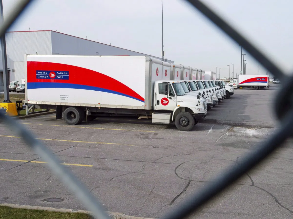 Idle Canada Post trucks sit in the parking lot of the Saint-Laurent sorting facility in Montreal, on Nov. 15, 2018. (The Canadian Press/Ryan Remiorz)