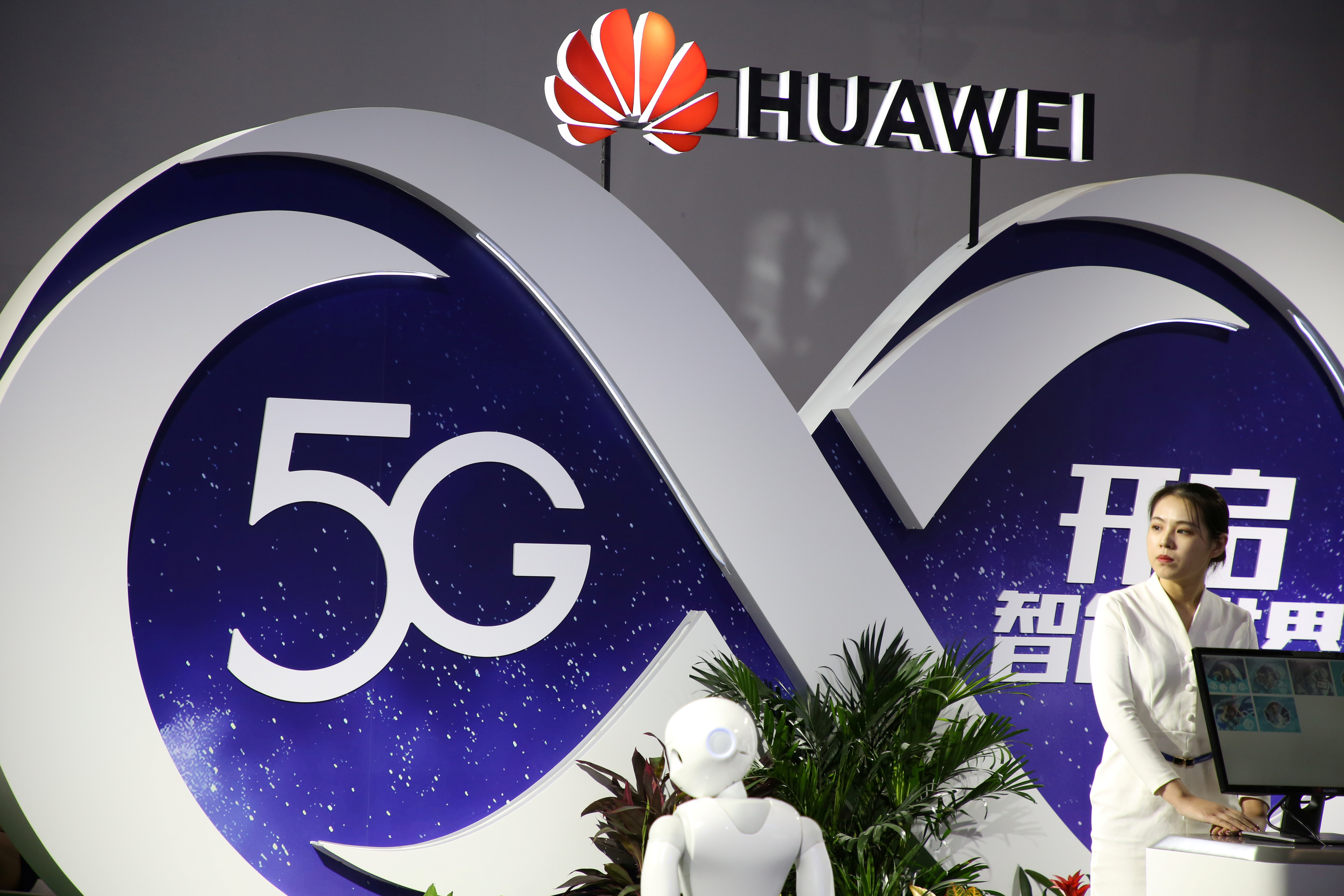 Женщина стоит у стенда компании Huawei, демонстрирующего технологию 5G, на выставке PT Expo в Пекине 28 сентября 2018 года. (Reuters)