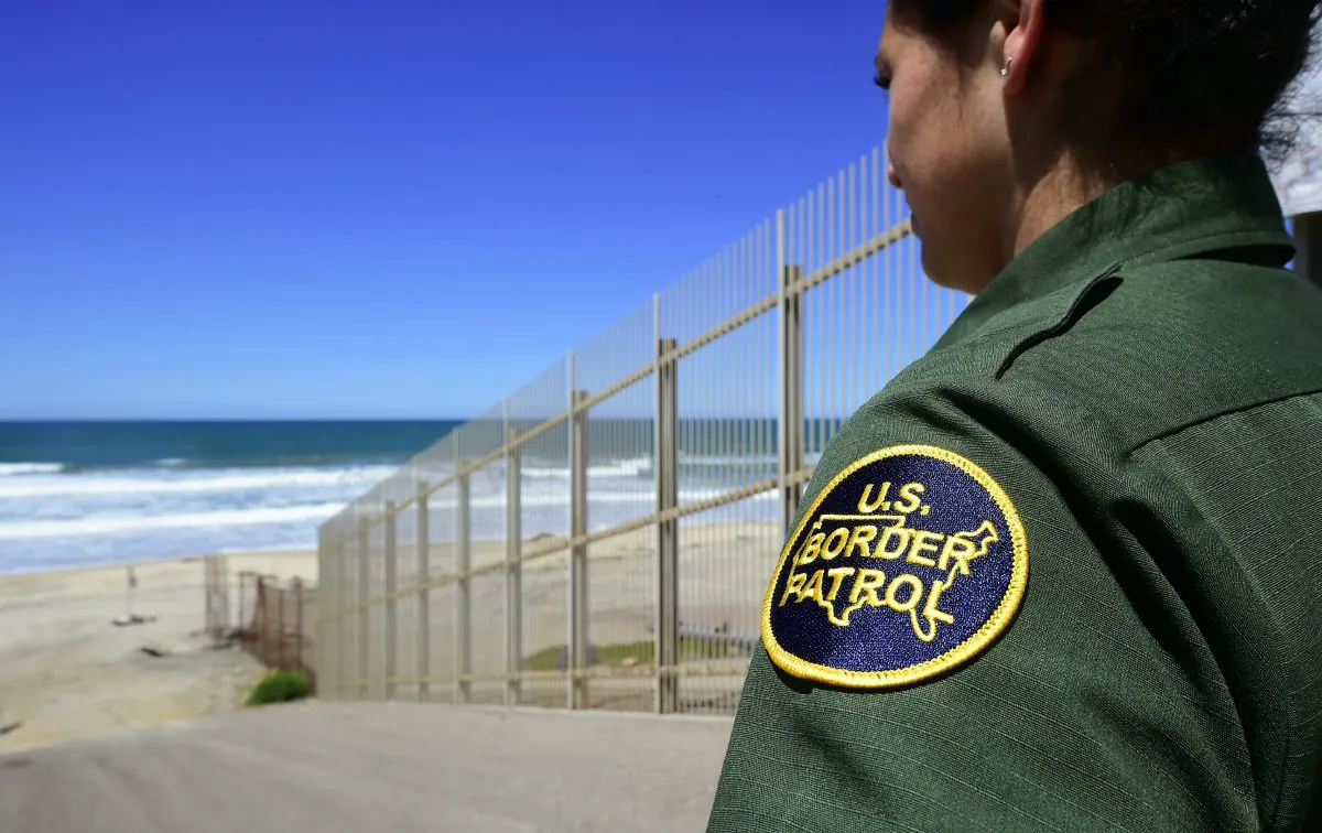 A U.S. Customs and Border Protection agent looks toward the ocean from within the Border Infrastructure System, a no man's land area between the wall and fence separating California from Mexico on April 17, 2018 in San Diego, California. The way we talk about immigration affects public opinion and government policy. (FREDERIC J. BROWN/AFP/Getty Images)