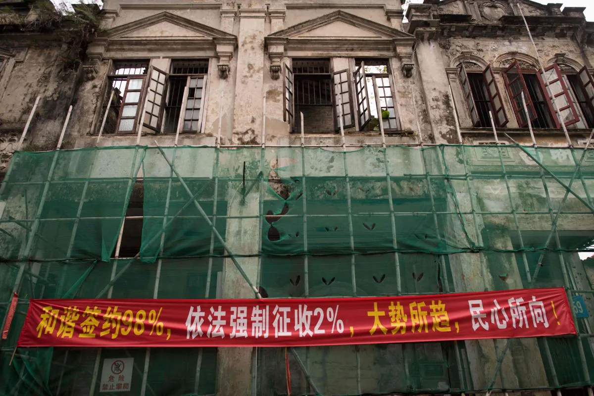 In this picture taken on May 28, 2018, a banner that reads "98 percent of people have signed contracts in a pleasing way, 2 percent of peoples houses have been forced-collected according to law, its the trend of the time and coinciding with the popular will" is seen on a building in Chikan village in Kaiping. (NICOLAS ASFOURI/AFP/Getty Images)
