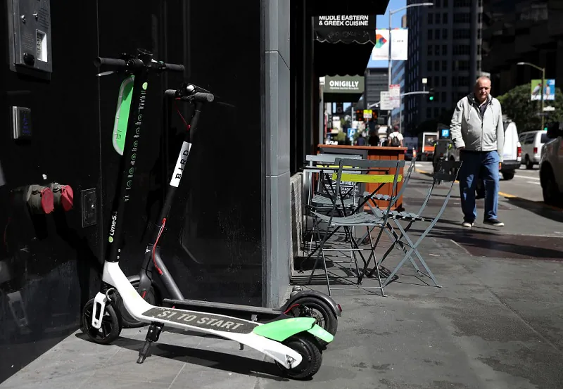 Bird and Lime scooters sit parked in front of a building in San Francisco, Cali, on April 17, 2018 (Justin Sullivan/Getty Images)