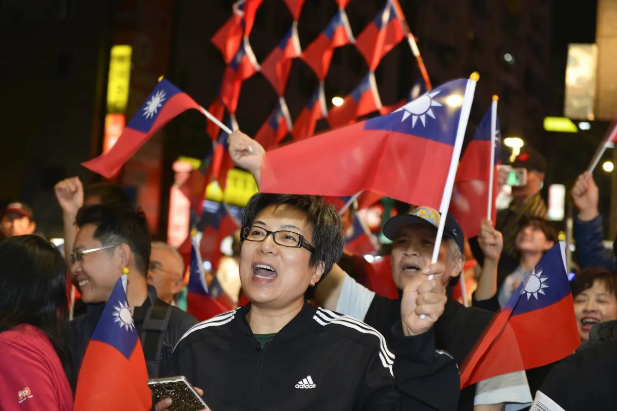 Supporters of mayoral candidate Ting Shou-chung from the Kuomintang (KMT) party wave national flags at Ting's campaign headquarters during local elections in Taipei, on Nov. 24, 2018. (Chris Stowers/AFP/Getty Images)