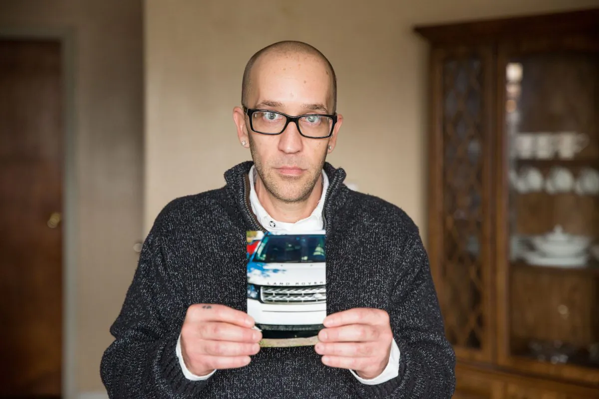 Tyson Timbs holds a picture of the Land Rover confiscated by the state of Indiana as part of a conviction for selling drugs. (Institute of Justice)