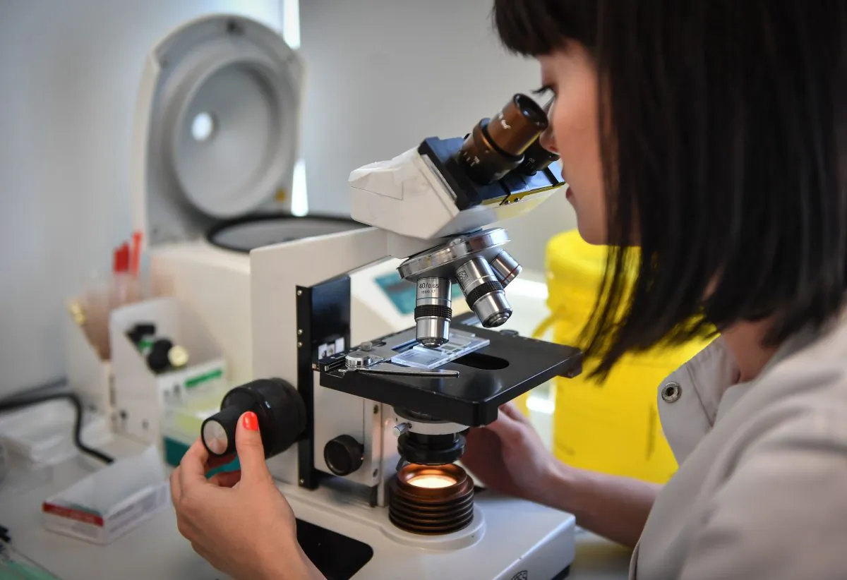 A medical employee uses a microscope at a microbiology laboratory in Bucharest, Romania, on April 12, 2018. (Daniel Mihailescu/AFP/Getty Images)