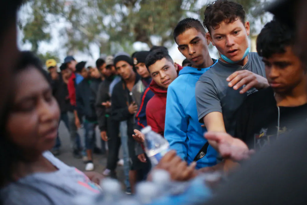 Migrants wait to receive donated food and water outside a temporary shelter set up for members of the migrant caravan in Tijuana, Mexico, on Nov. 28, 2018. (Mario Tama/Getty Images)